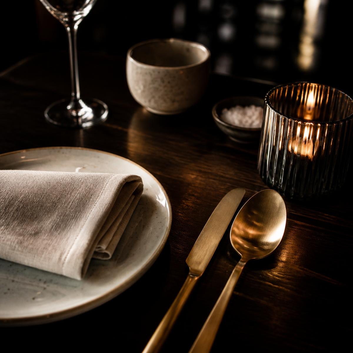 Gedeckter Tisch mit Kerzenlicht im Detail